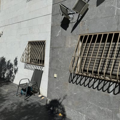 סורגים מתכתיים על חלונות קיר חיצוני אפור