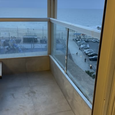 מרפסת עם מעקה זכוכית ונוף לים