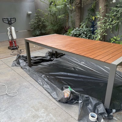 שולחן עץ עם כיסוי פלסטיק וכלי עבודה בגינה
