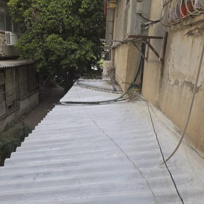 גג אטום עם צינורות ומזגנים ליד בניין