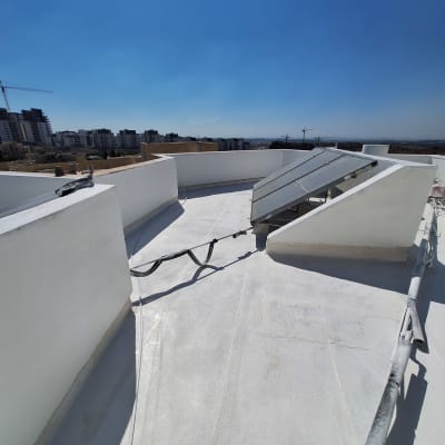גג אטום עם ציפוי לבן וצינורות חשופים