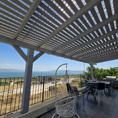 פרגולה מעץ עם שולחן וכיסאות בגינה