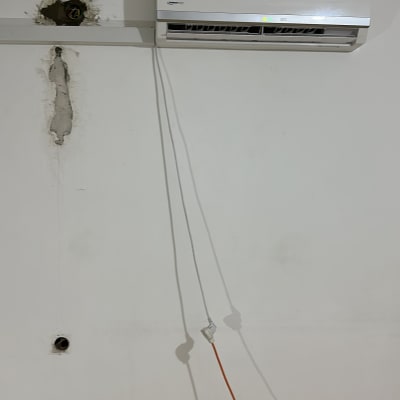 מזגן מותקן על קיר עם חוטי חשמל גלויים