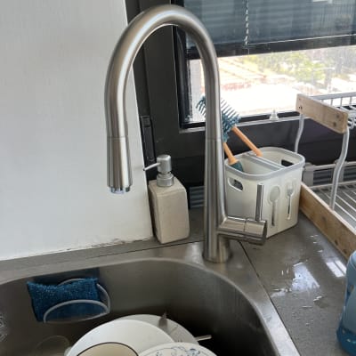 ברז נירוסטה מעל כיור עם כלים מלוכלכים