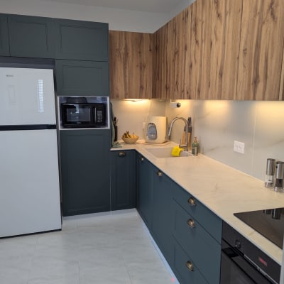 מטבח מודרני עם ארונות עץ, כיור ותנור.