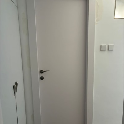 דלת לבנה עם ידית מתכת בחדר