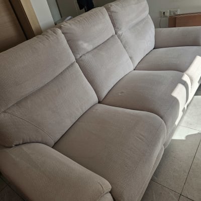 ספה בהירה בחדר מגורים עם אור שמש