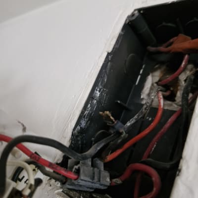 חוטי חשמל צבעוניים בתיבת חיבורים בקיר