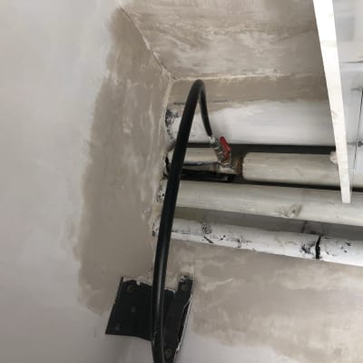 קיר צבוע עם תיקוני צבע ליד צינורות