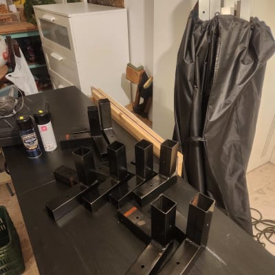 חלקי מתכת שחורים על שולחן, כנראה חלקים למסגרות