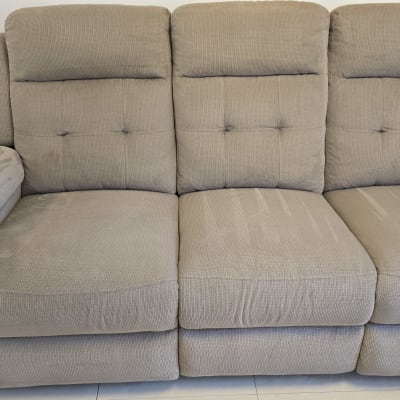 ספה אפורה עם כתמי לכלוך על המושב והמשענת