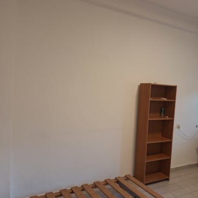 קיר צבוע בלבן עם מדף עץ ריק