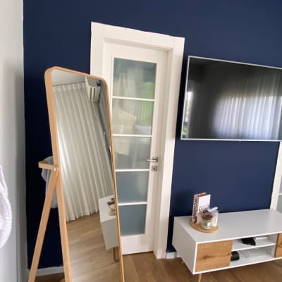 חדר עם מראה עומדת, דלת זכוכית וטלוויזיה על הקיר