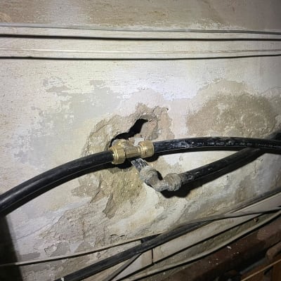 צינורות שחורים עם מחברים בקיר בטון