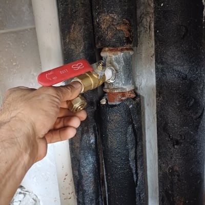 יד מחזיקה ברז על צינור מתכת חלוד