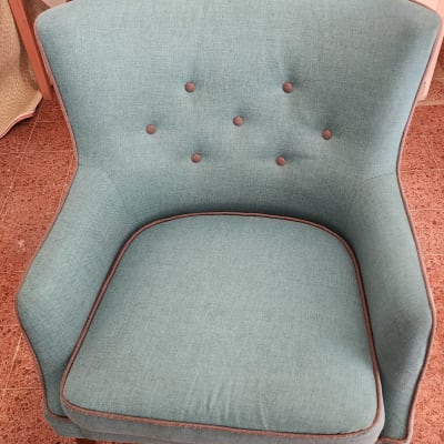 כורסה ירוקה עם כפתורים על רצפת אריחים