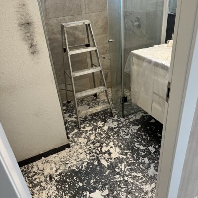 חדר אמבטיה עם סולם ופסולת בנייה על הרצפה