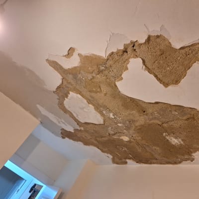 תקרה מתקלפת עם טיח חשוף וכתמי צבע