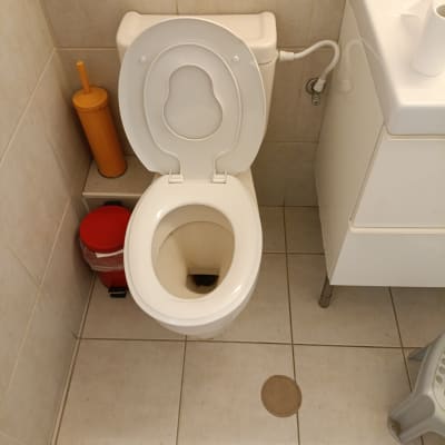 אסלה, מברשת שירותים, כיור וצינור בחדר אמבטיה