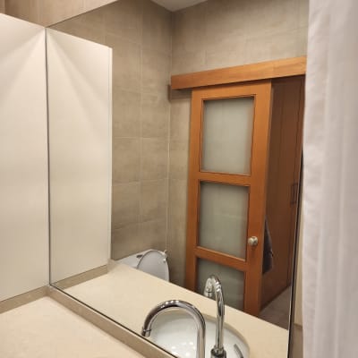 מראה וכיור בחדר אמבטיה עם דלת זכוכית