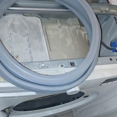 מכונת כביסה פתוחה עם גומייה מונחת על החלק העליון