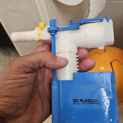 חלק פלסטיק כחול עם יד מחזיקה, רקע של שירותים