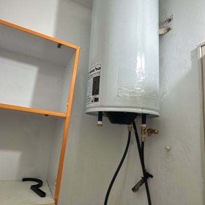 דוד שמש מותקן על קיר עם צינורות מחוברים