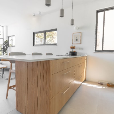 אי מטבח מעץ עם מגירות ותאורה תלויה