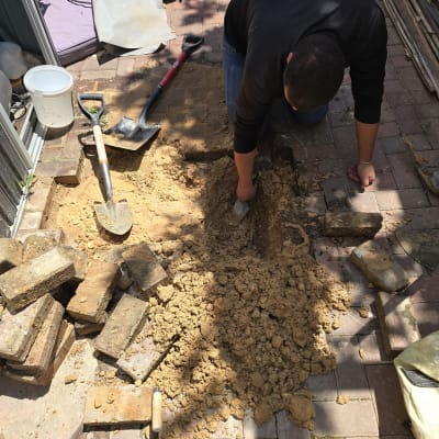 אדם חופר באדמה עם כלים לידו