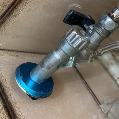 שסתום מתכת עם צינור גמיש על קיר אריחים