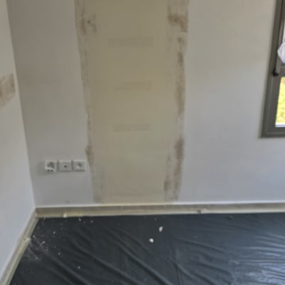 קיר צבוע עם סימני תיקון, יריעת מגן על הרצפה