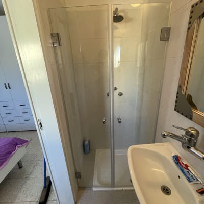 מקלחון זכוכית עם ראש מקלחת ובקבוק סבון