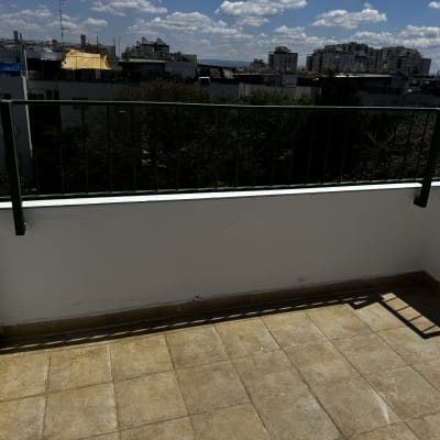 מרפסת עם מעקה מתכת ירוק ורצפת אריחים