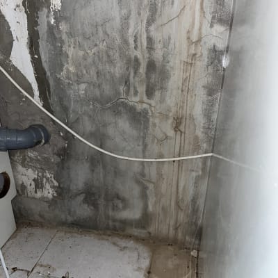 הכנת צנרת מים ואינסטלציה בקיר חשוף במהלך עבודת אינסטלטור
