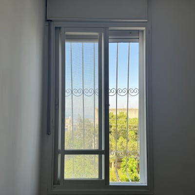 חלון עם תריסים ומסגרת מתכת