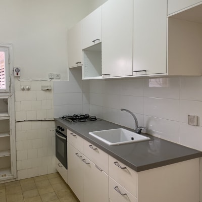 מטבח נקי עם כיור וברז, ארונות לבנים