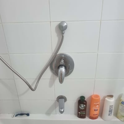 ברז אמבטיה עם ידית וכמה בקבוקים על שפת האמבטיה