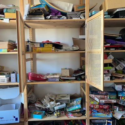 מדפים עמוסים במשחקי קופסה וצעצועים שונים