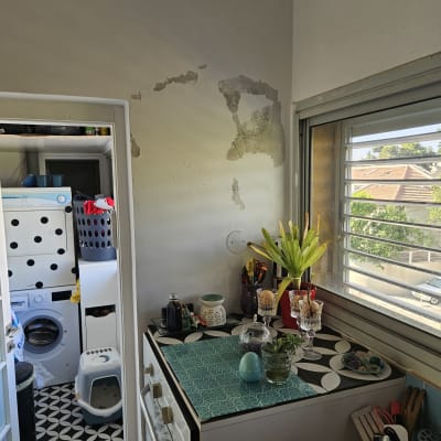 קיר עם סימני רטיבות ליד חלון פתוח