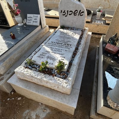 מצבות עם כיתוב בעברית ואבנים קטנות