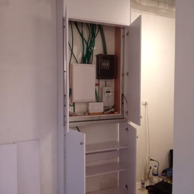 ארון פתוח עם מדפים ודלתות, חוטים חשמליים גלויים