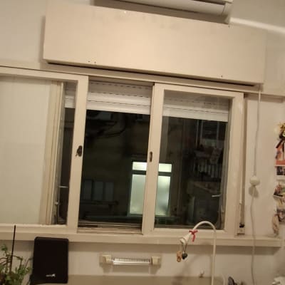 חלון עם תריסים ומזגן מעל שולחן