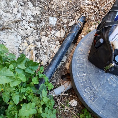 צינור שחור ליד מכסה עגול עם תיק עבודה