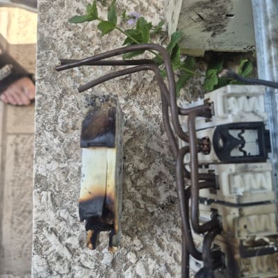 חלקים חשמליים שרופים על משטח בטון