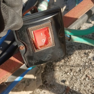 מתג חשמלי אדום עם חוטים כחולים וירוקים