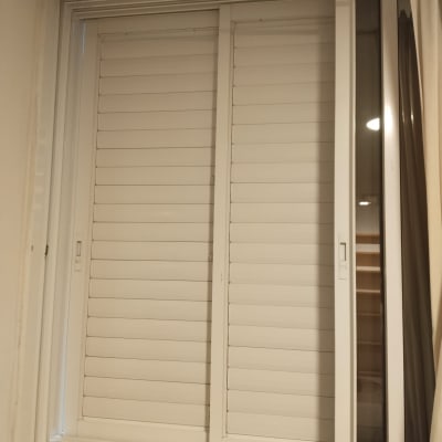 חלון עם תריסים סגורים בחדר מואר