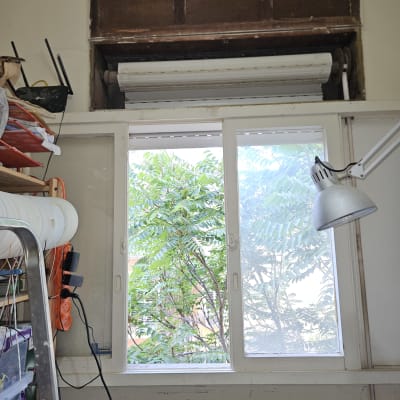 תריס גלילה מעל חלון עם מנורה ולוח עבודה