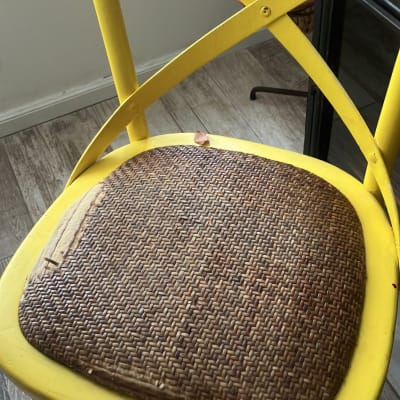 כיסא צהוב עם מושב קש פגום