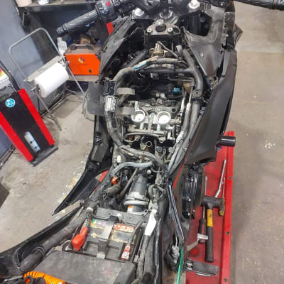 אופנוע מפורק עם חלקים חשופים במוסך