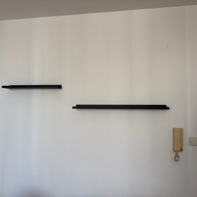 מדפים שחורים מותקנים על קיר לבן